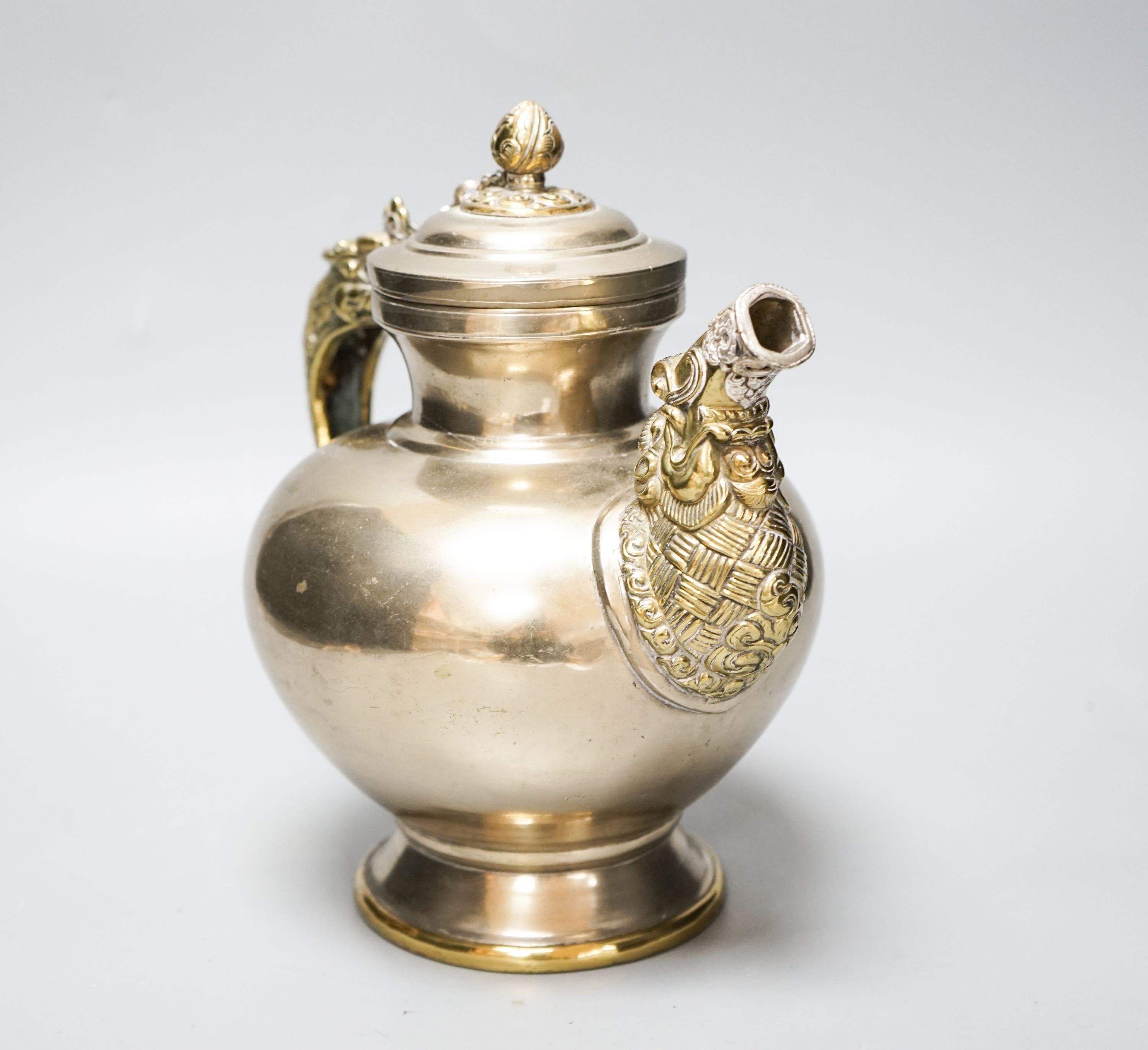 A late 19th/early 20th century Tibetan paktong, bronze and silver mounted teapot, 24cm